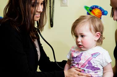 A photo of a female doctor treating a child.