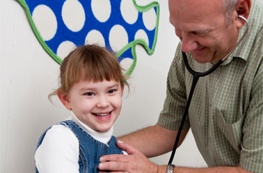 A photo of a doctor treating a female child patient.